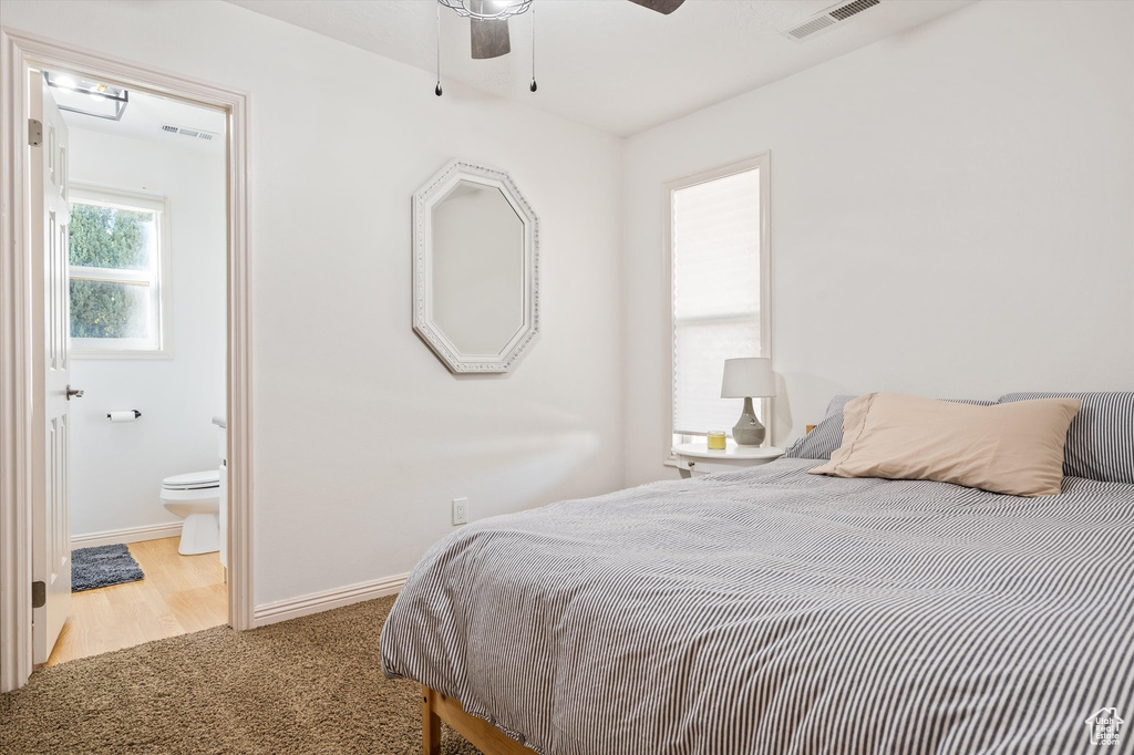 Carpeted bedroom with baseboards and connected bathroom