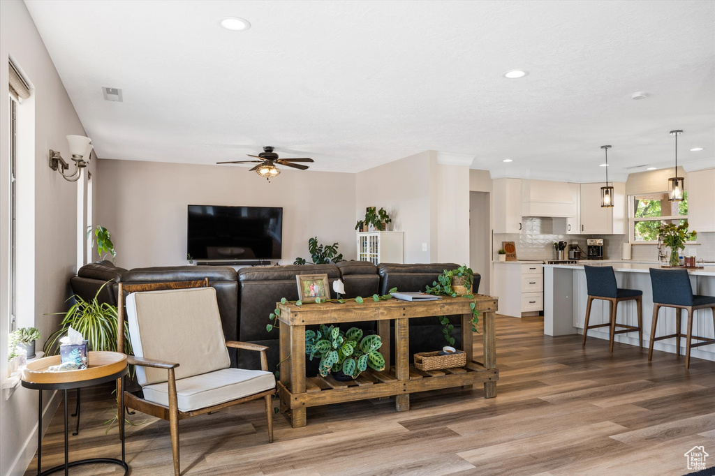 Living area featuring ceiling fan, light wood-type flooring, and recessed lighting