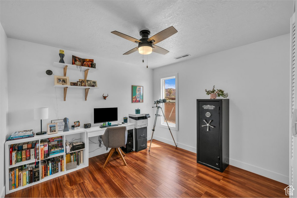 Office featuring a ceiling fan, baseboards, wood finished floors, and a textured ceiling