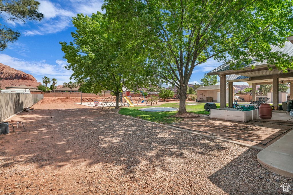 View of yard featuring fence, a playground, and a patio area