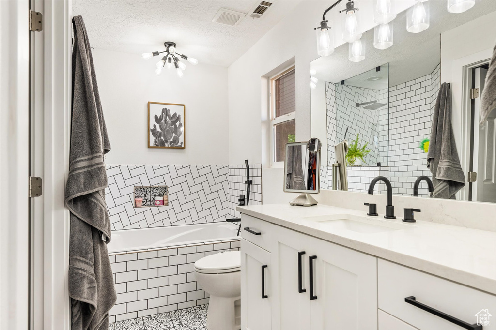 Full bath with tiled bath, vanity, tile patterned floors, toilet, and a tile shower