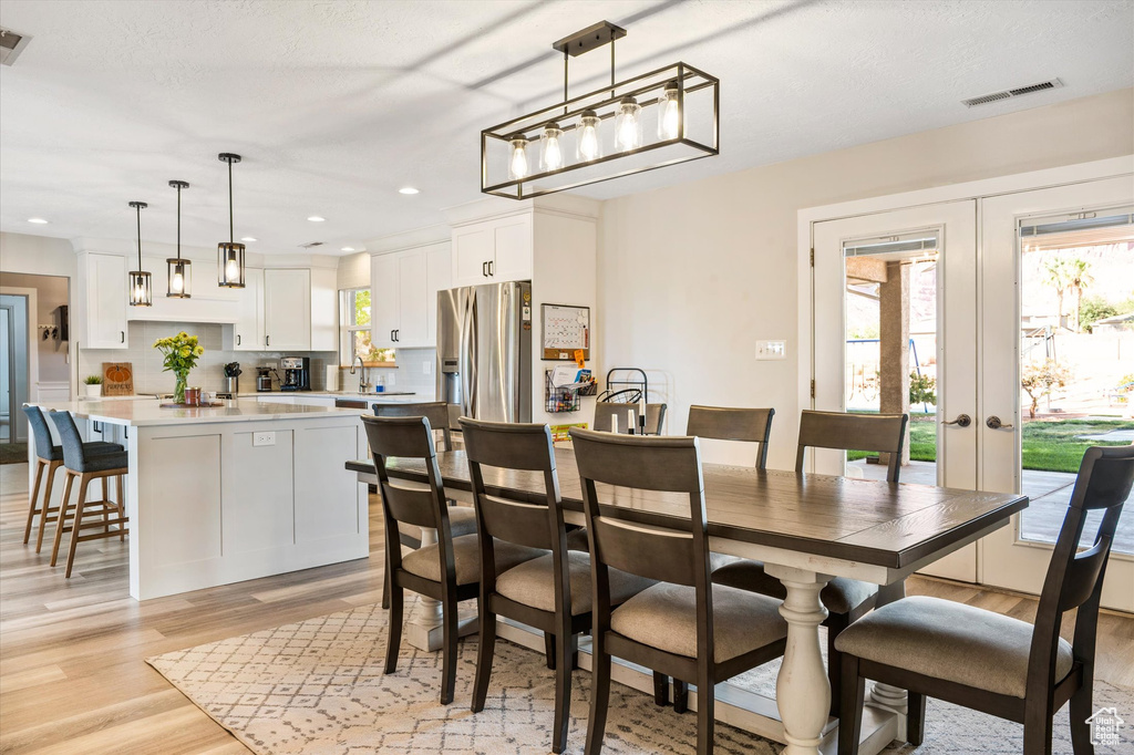 Dining space featuring light wood finished floors, french doors, and recessed lighting