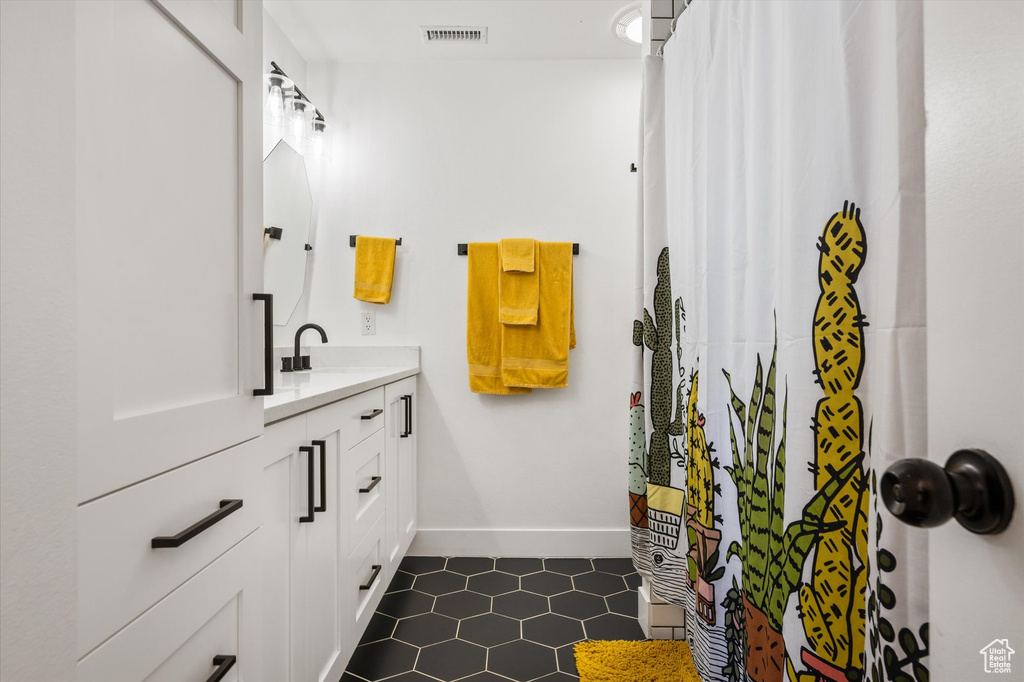 Bathroom featuring tile patterned flooring, vanity, baseboards, and a shower with curtain