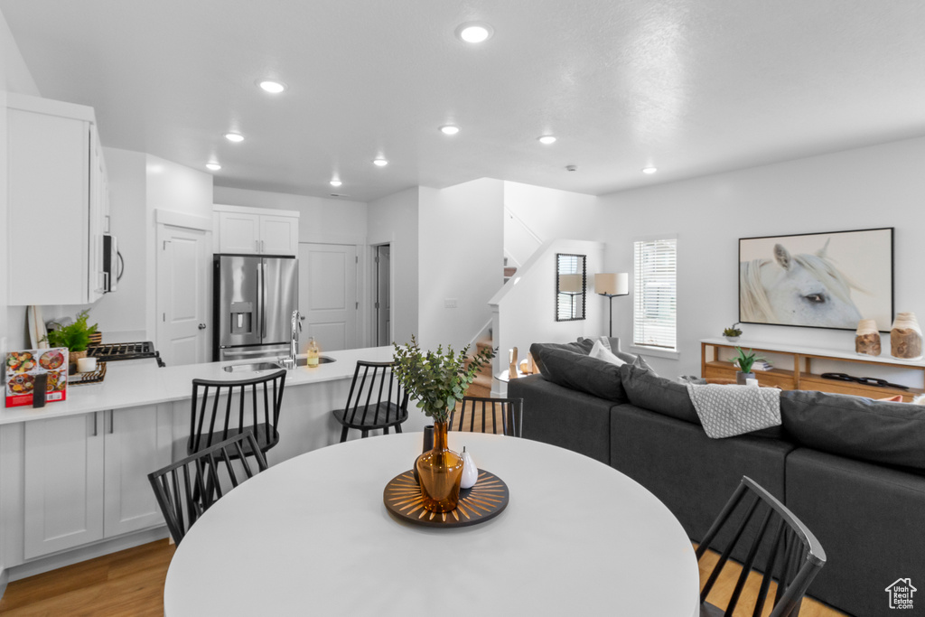 Dining area with stairway, recessed lighting, and light wood-type flooring