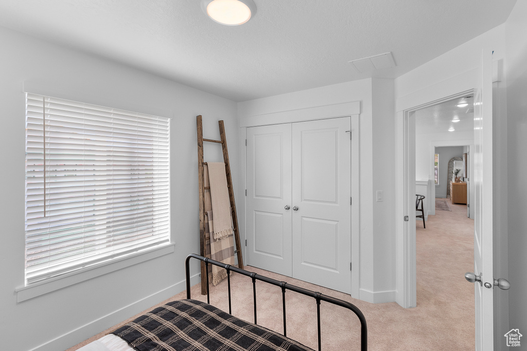 Carpeted bedroom with a closet and baseboards
