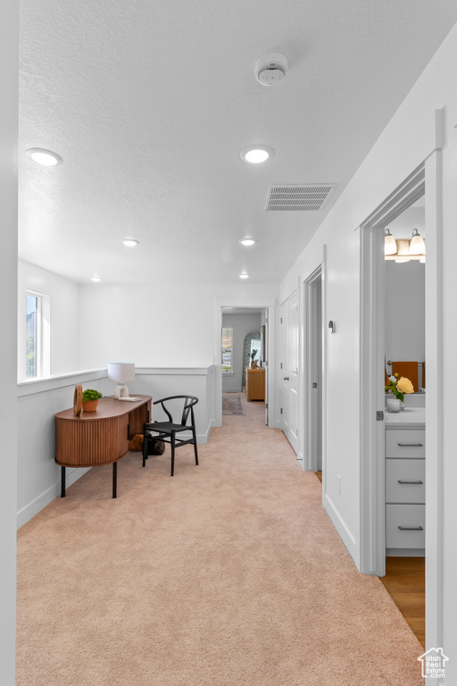 Hallway with carpet, plenty of natural light, baseboards, and recessed lighting