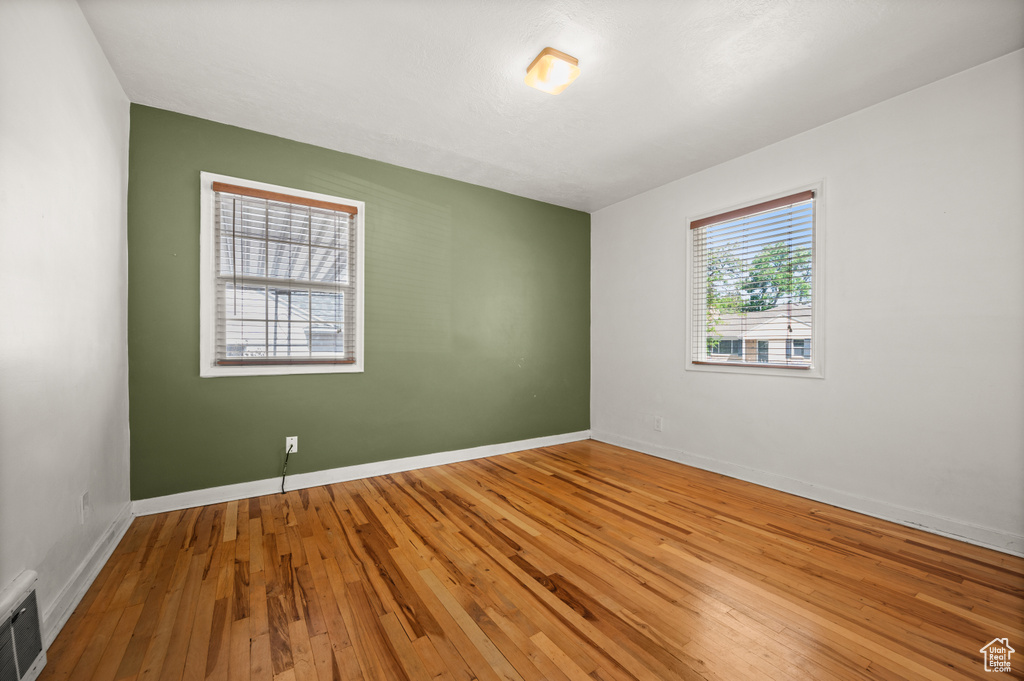 Empty room with wood-type flooring and baseboards