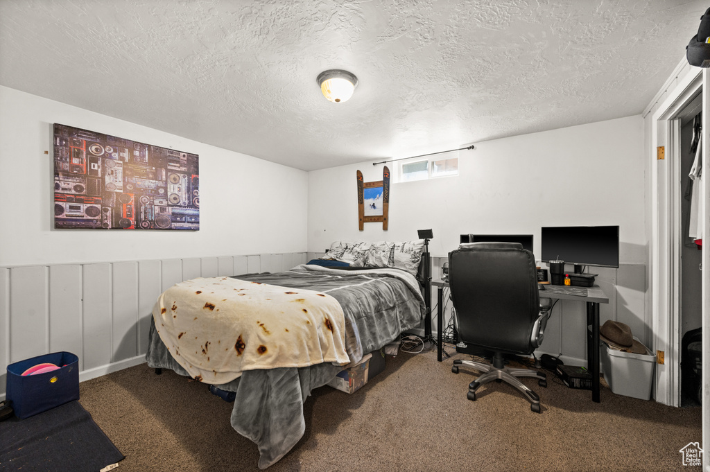 Bedroom featuring carpet and a textured ceiling