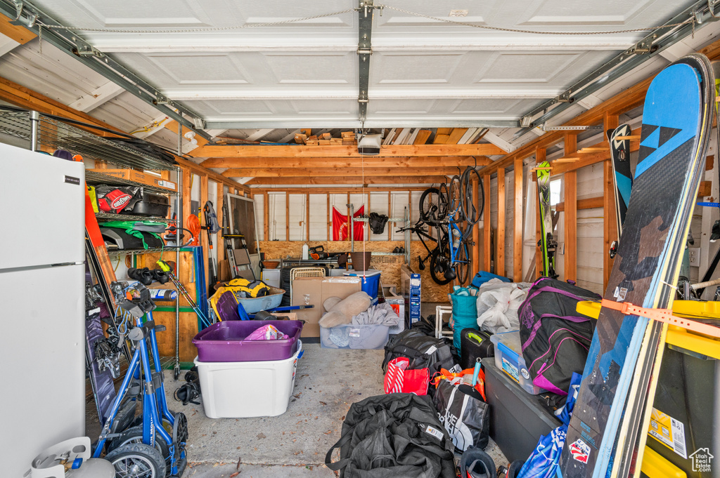 Garage featuring freestanding refrigerator and a garage door opener