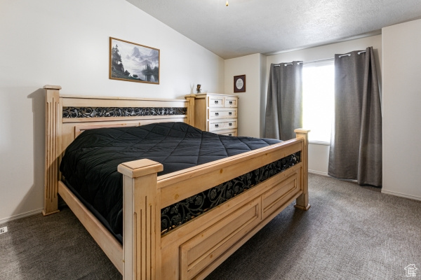 Bedroom with carpet flooring, vaulted ceiling, and baseboards