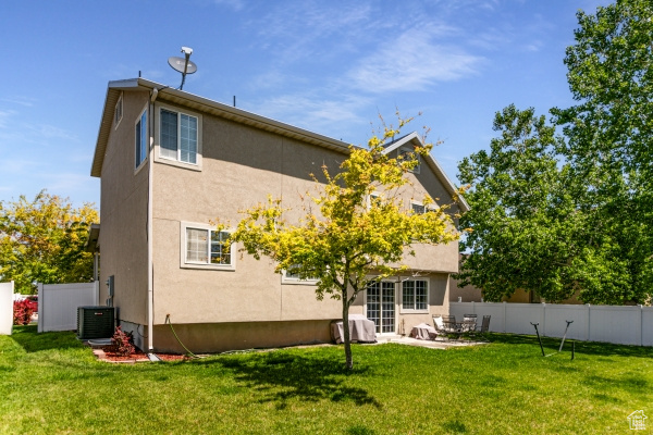 Rear view of house with stucco siding and central air condition unit