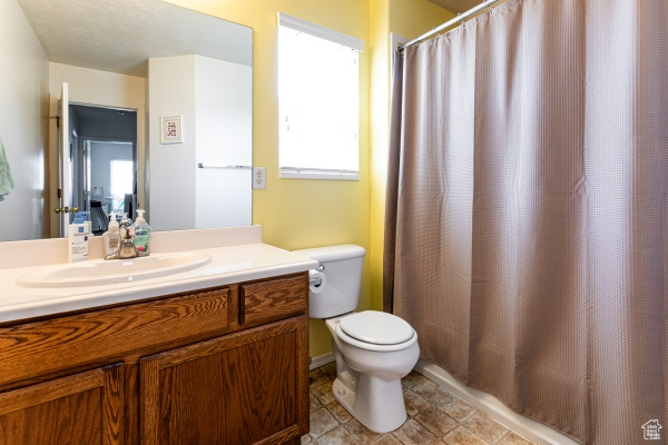 Bathroom with vanity, toilet, and a shower with shower curtain