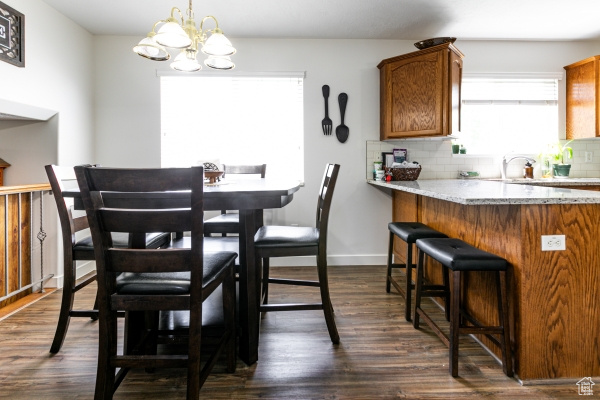 Dining room featuring a chandelier, dark wood-style floors, and baseboards