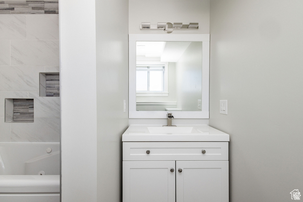 Full bathroom with vanity and a combined bath / shower with jetted tub