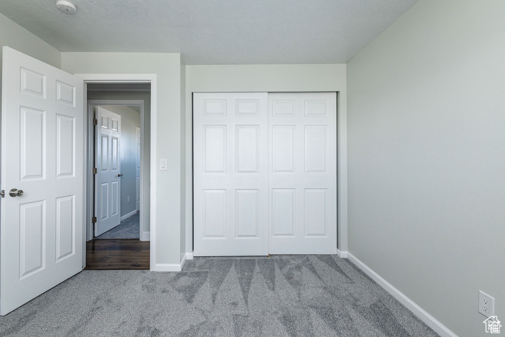 Unfurnished bedroom with carpet flooring, baseboards, and a closet
