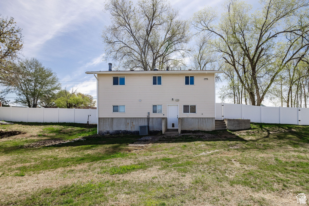 Rear view of house featuring entry steps and central AC unit