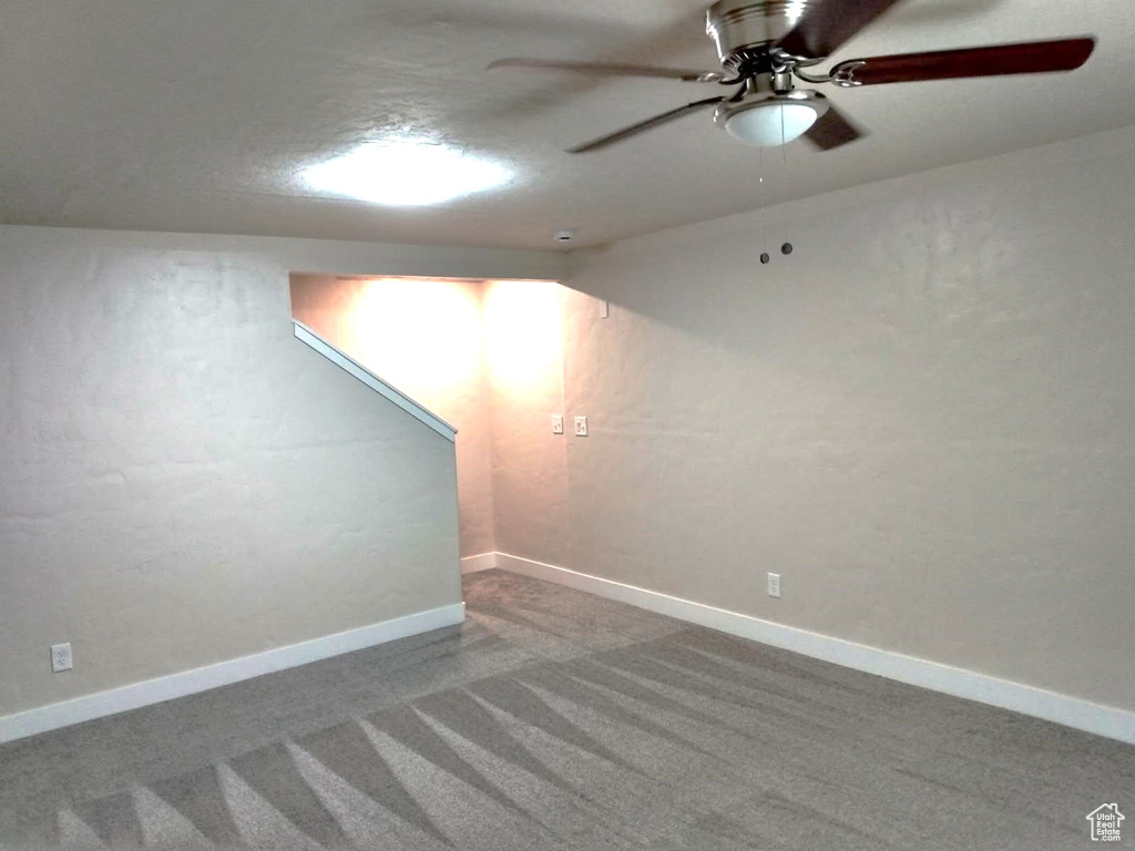 Finished below grade area with carpet flooring, a ceiling fan, and baseboards
