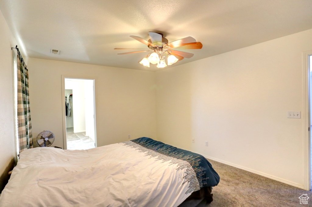 Carpeted bedroom featuring baseboards and a ceiling fan