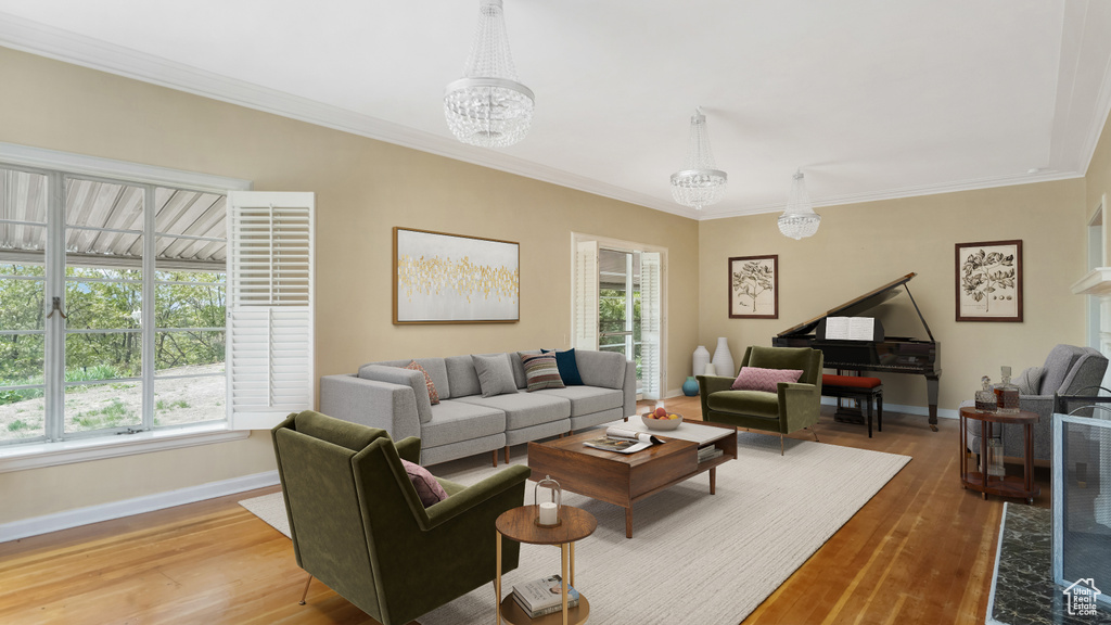 Living area featuring baseboards, wood finished floors, a chandelier, and ornamental molding