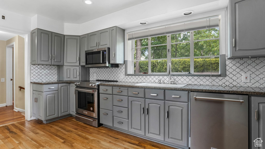 Kitchen featuring gray cabinets, appliances with stainless steel finishes, a sink, and recessed lighting