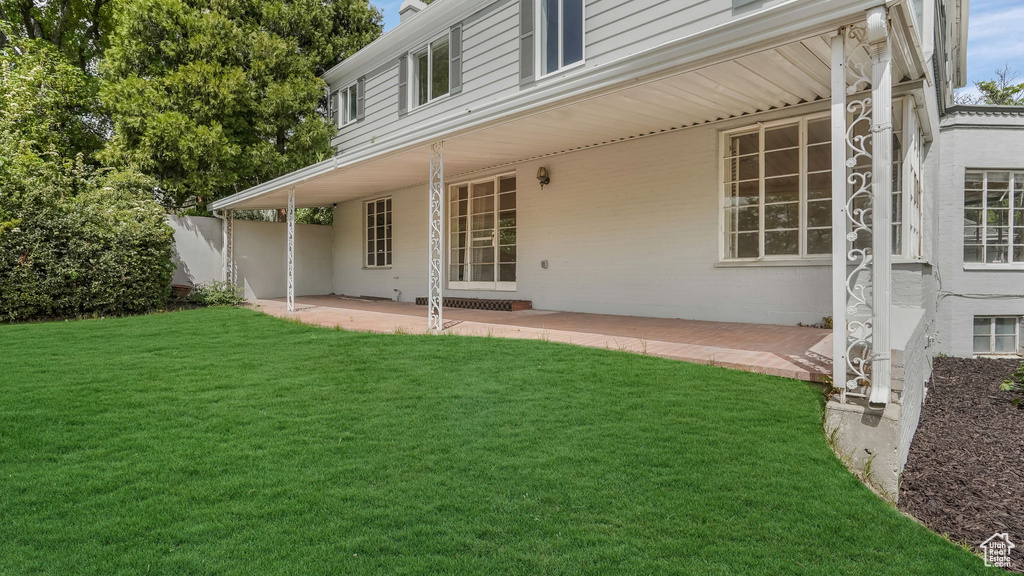 Rear view of property with a patio area and a lawn