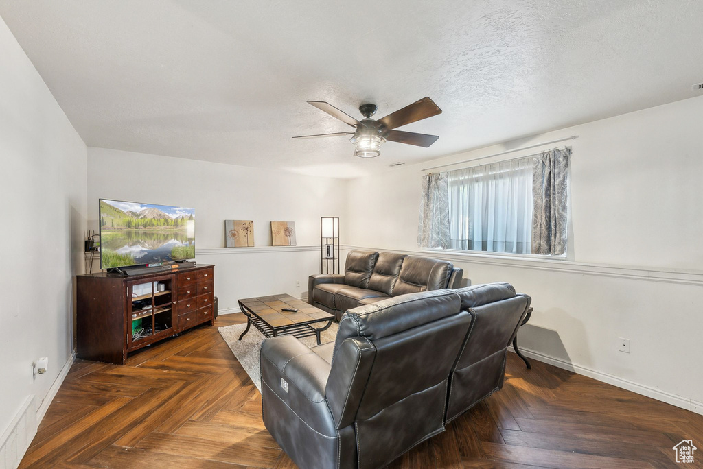 Living room featuring plenty of natural light, ceiling fan, and baseboards