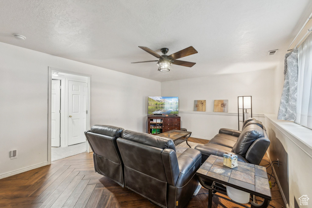 Living room featuring a ceiling fan and baseboards