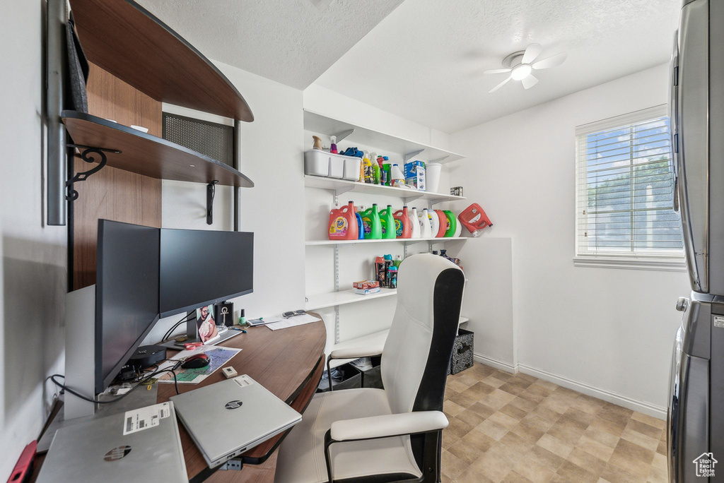 Office area with ceiling fan, baseboards, and a textured ceiling
