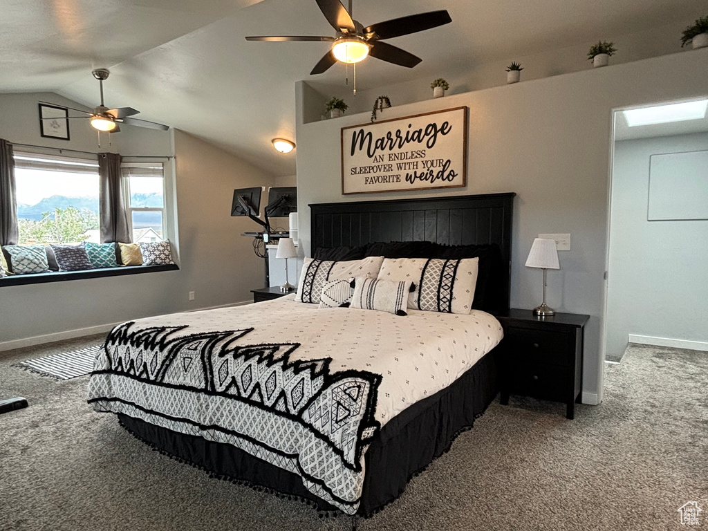 Carpeted bedroom featuring baseboards, lofted ceiling, and ceiling fan