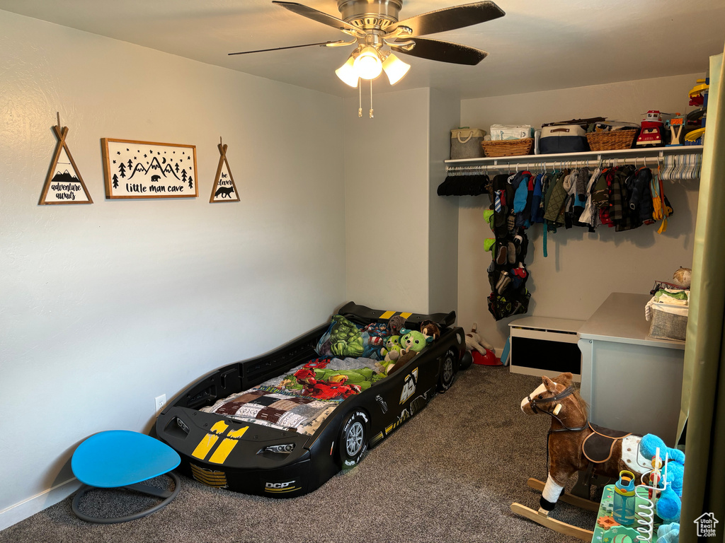 Carpeted bedroom with a ceiling fan
