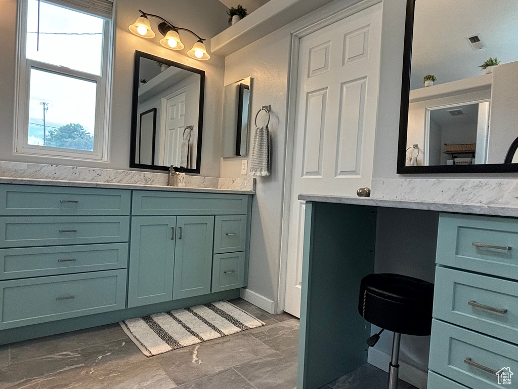 Bathroom featuring marble look tile flooring and vanity