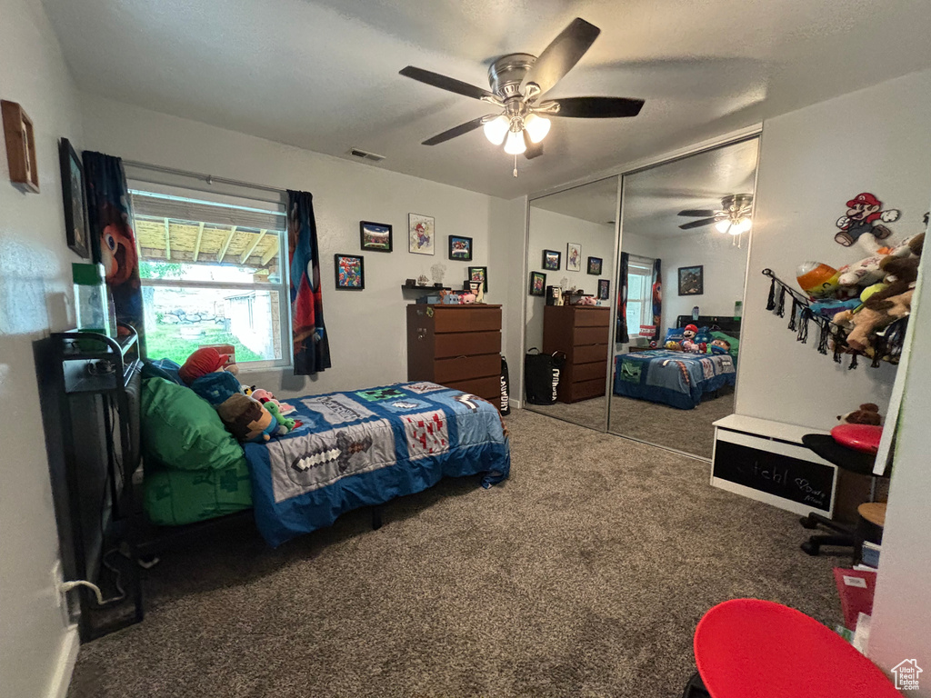 Carpeted bedroom featuring a closet and ceiling fan