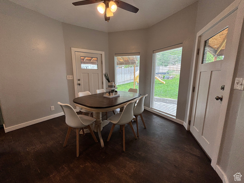 Dining area with dark wood finished floors, ceiling fan, and baseboards