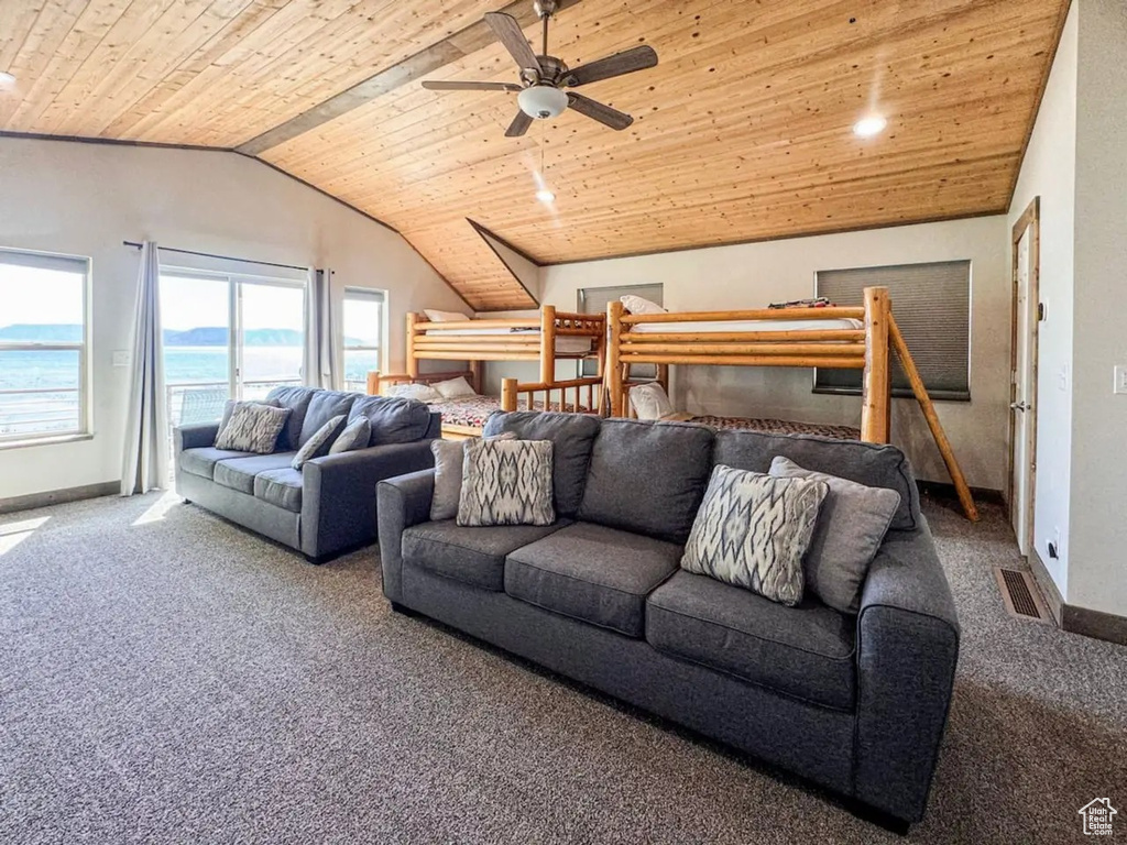 Living room featuring wooden ceiling, carpet flooring, lofted ceiling, baseboards, and ceiling fan