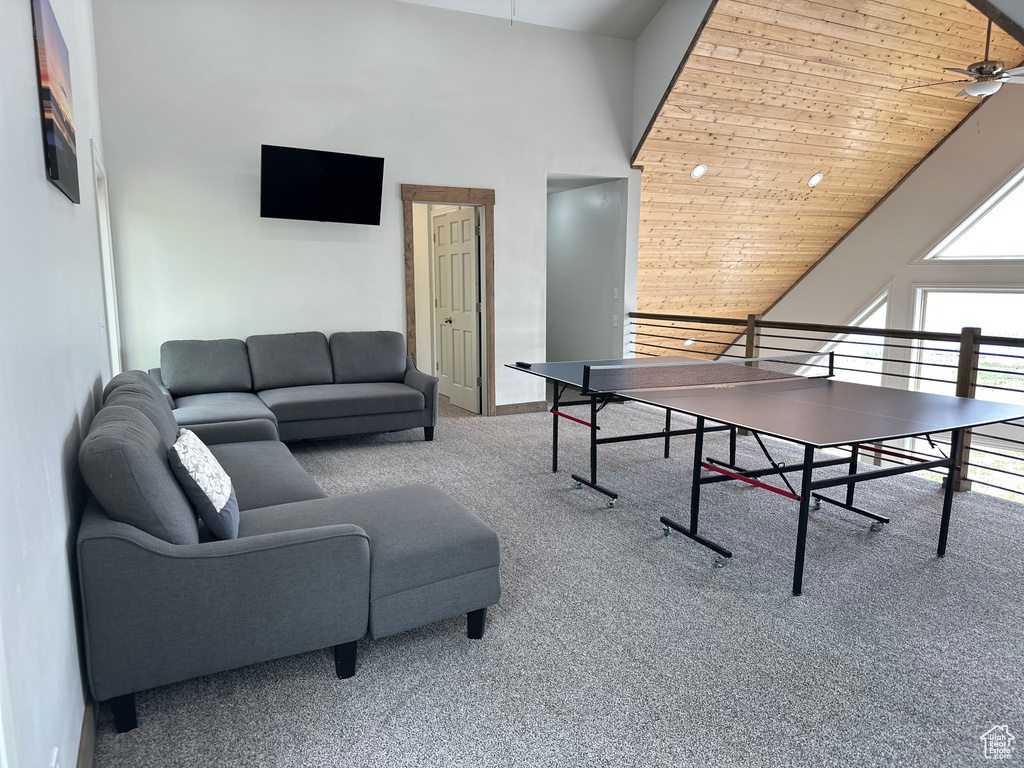 Playroom with ceiling fan, carpet floors, a high ceiling, wood ceiling, and baseboards