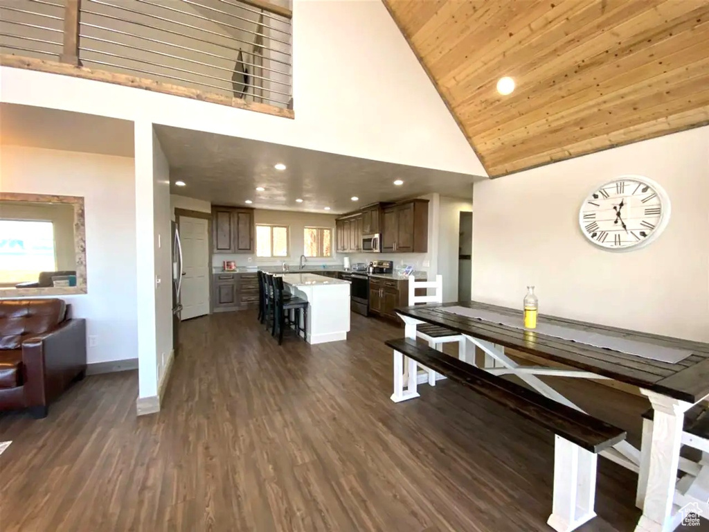 Dining space with high vaulted ceiling, baseboards, dark wood-type flooring, recessed lighting, and wooden ceiling