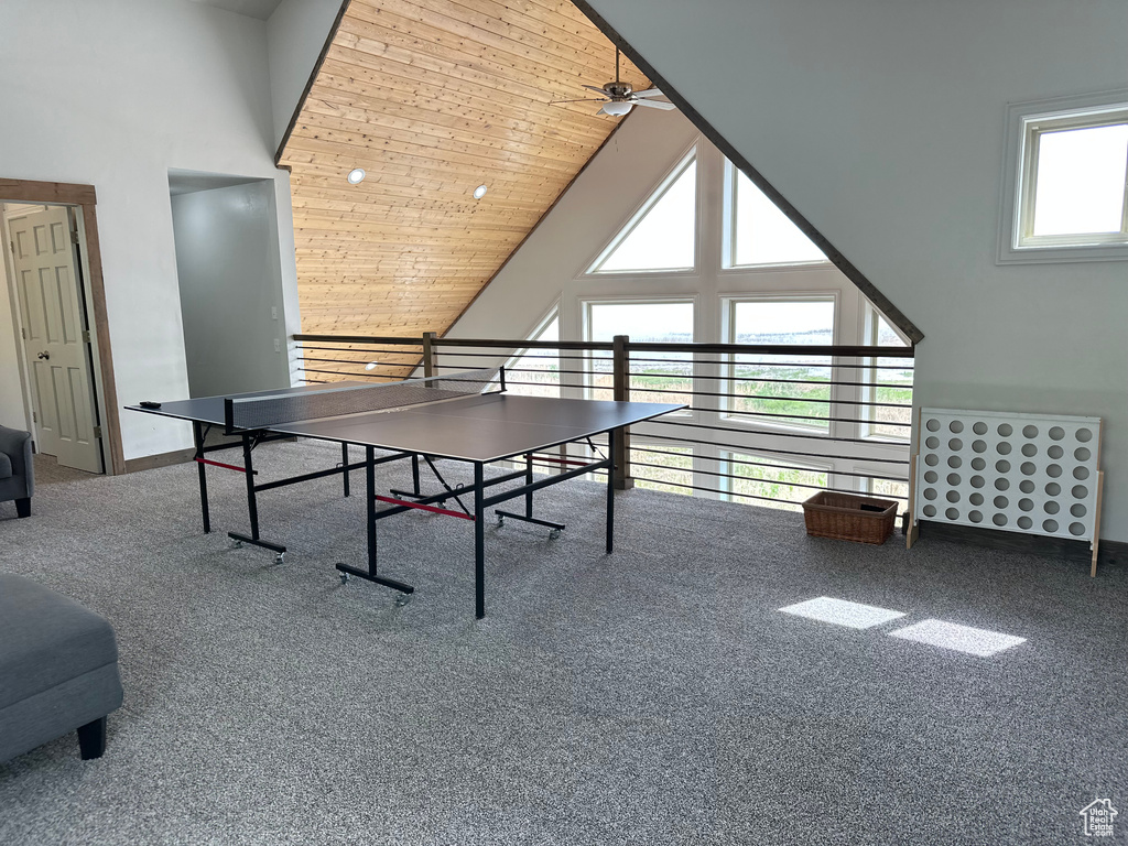 Recreation room with high vaulted ceiling, a ceiling fan, wooden ceiling, and baseboards
