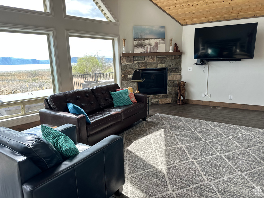Living room with lofted ceiling, wooden ceiling, wood finished floors, a fireplace, and baseboards