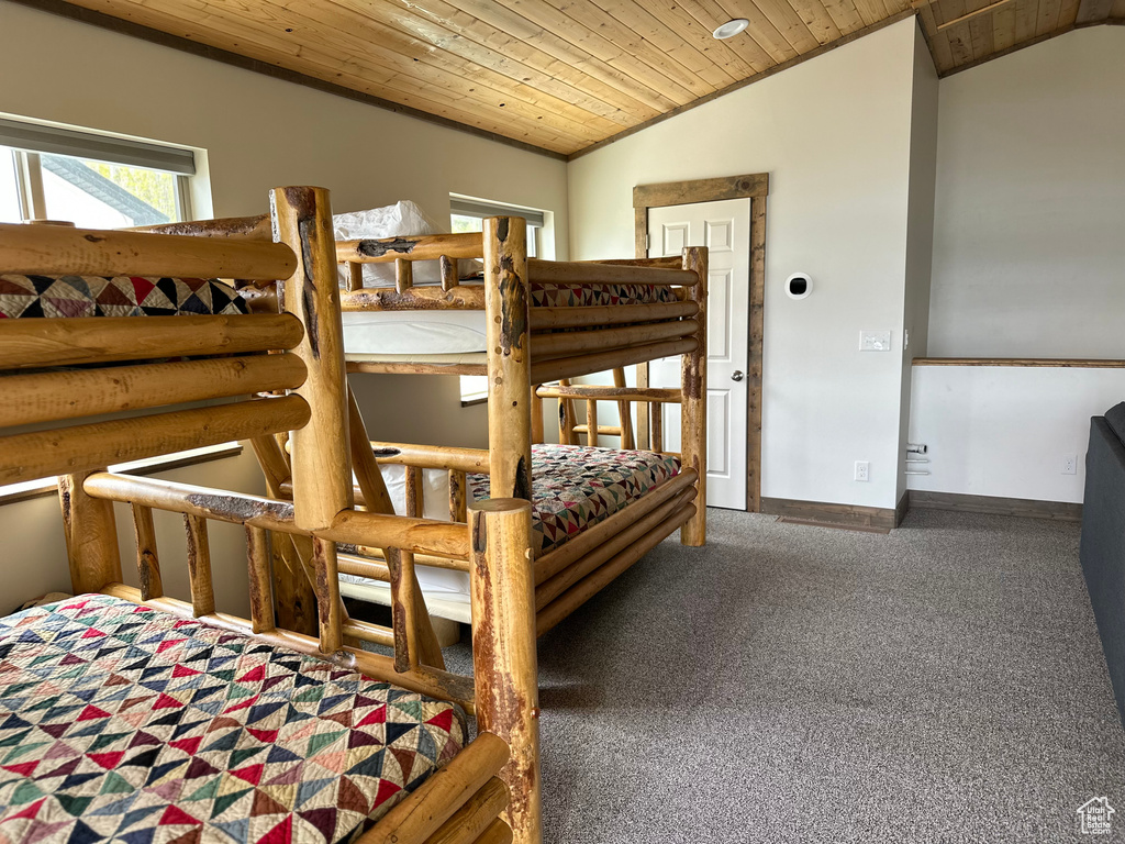 Carpeted bedroom with wooden ceiling, lofted ceiling, and baseboards