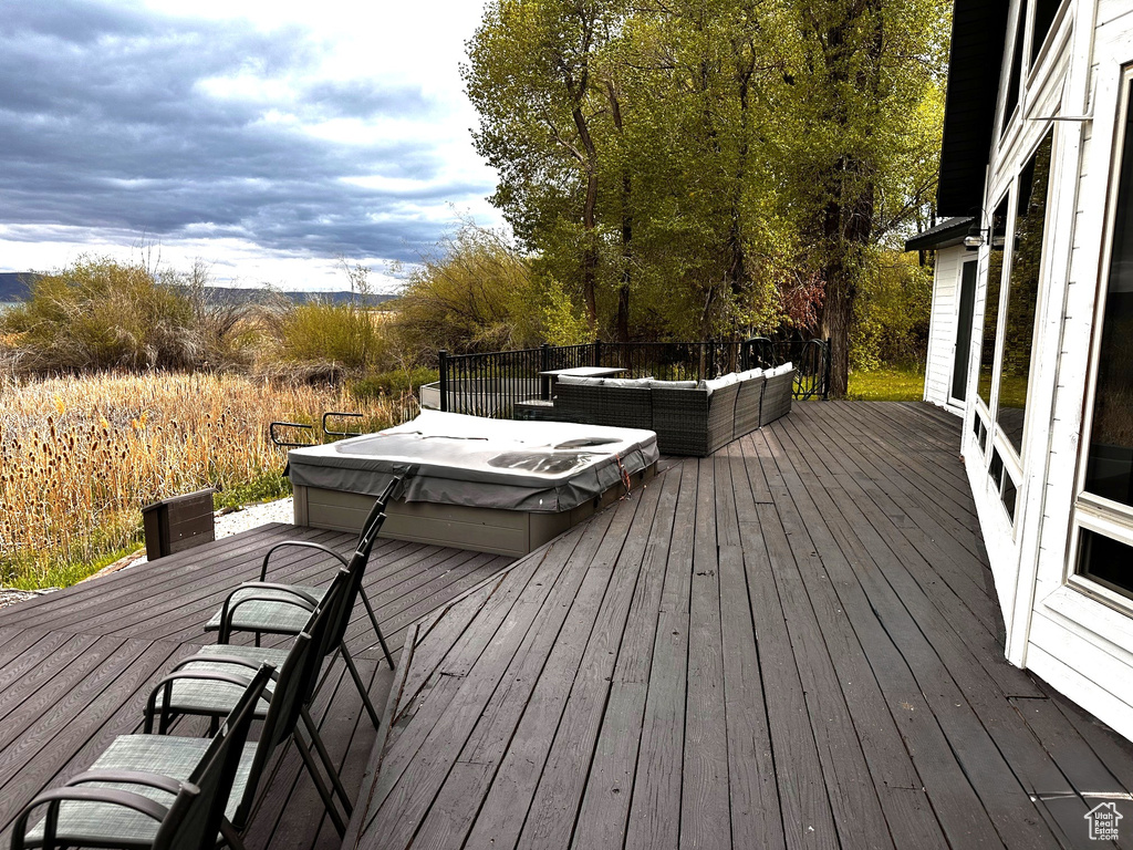 Deck featuring outdoor lounge area and a covered hot tub