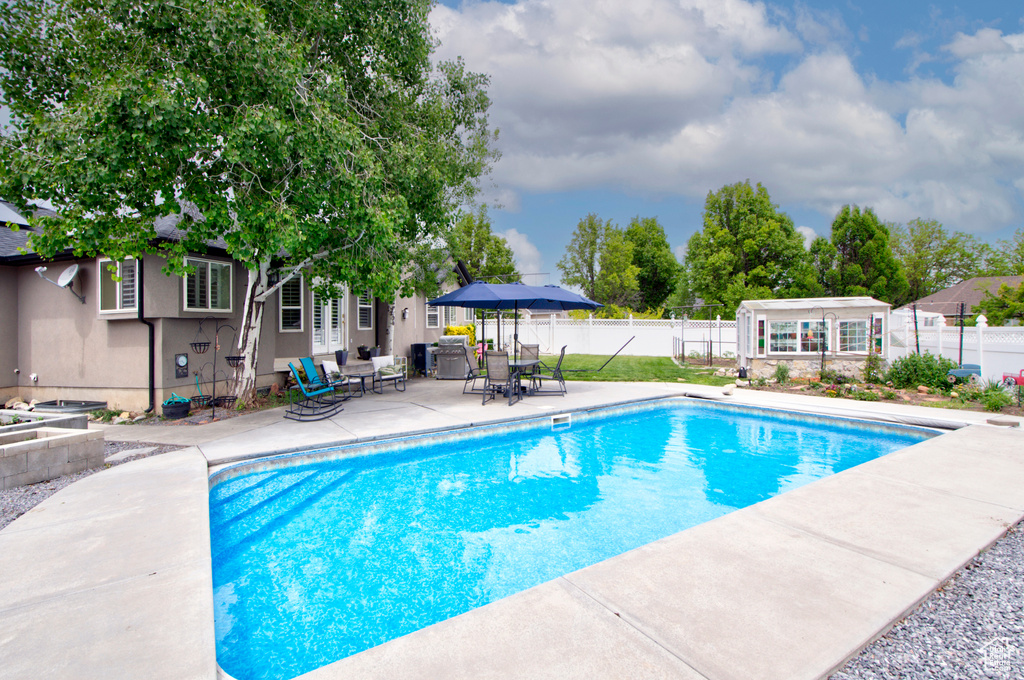 View of pool with a patio and fence