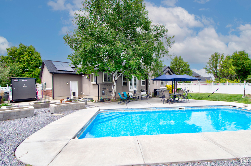 View of pool with a patio area, fence, and outdoor dining space