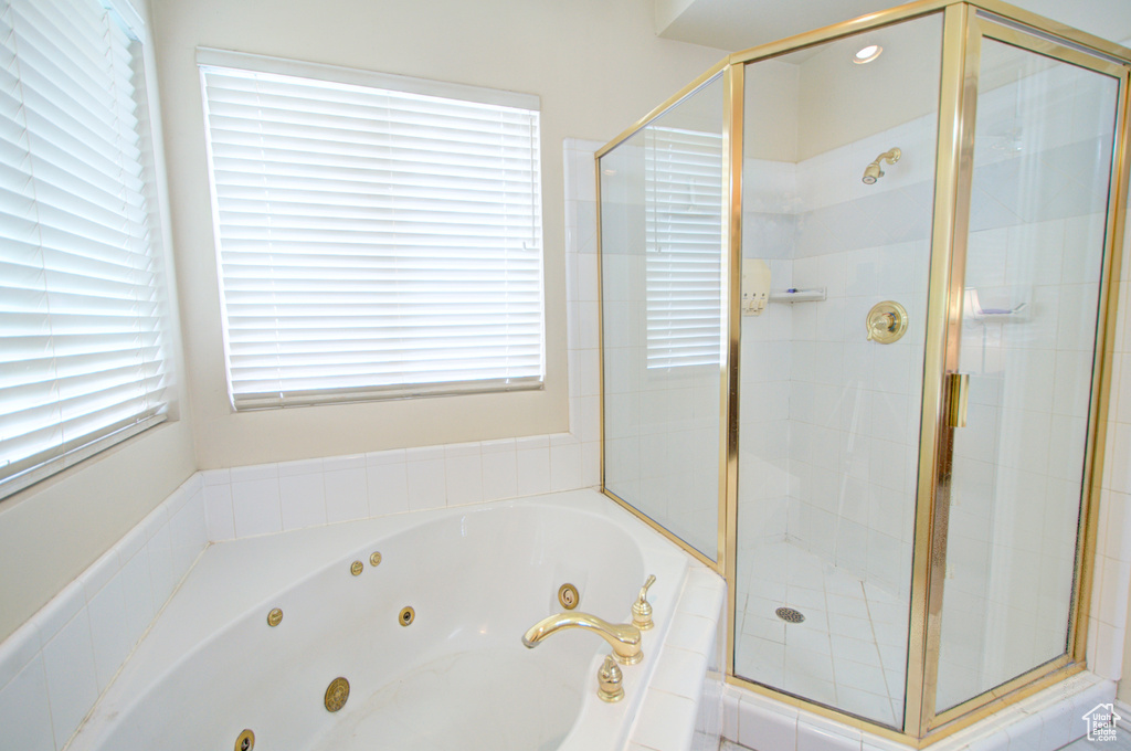Bathroom with a tub with jets and a stall shower