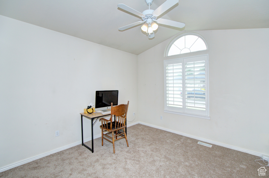 Carpeted office featuring vaulted ceiling, plenty of natural light, a ceiling fan, and baseboards