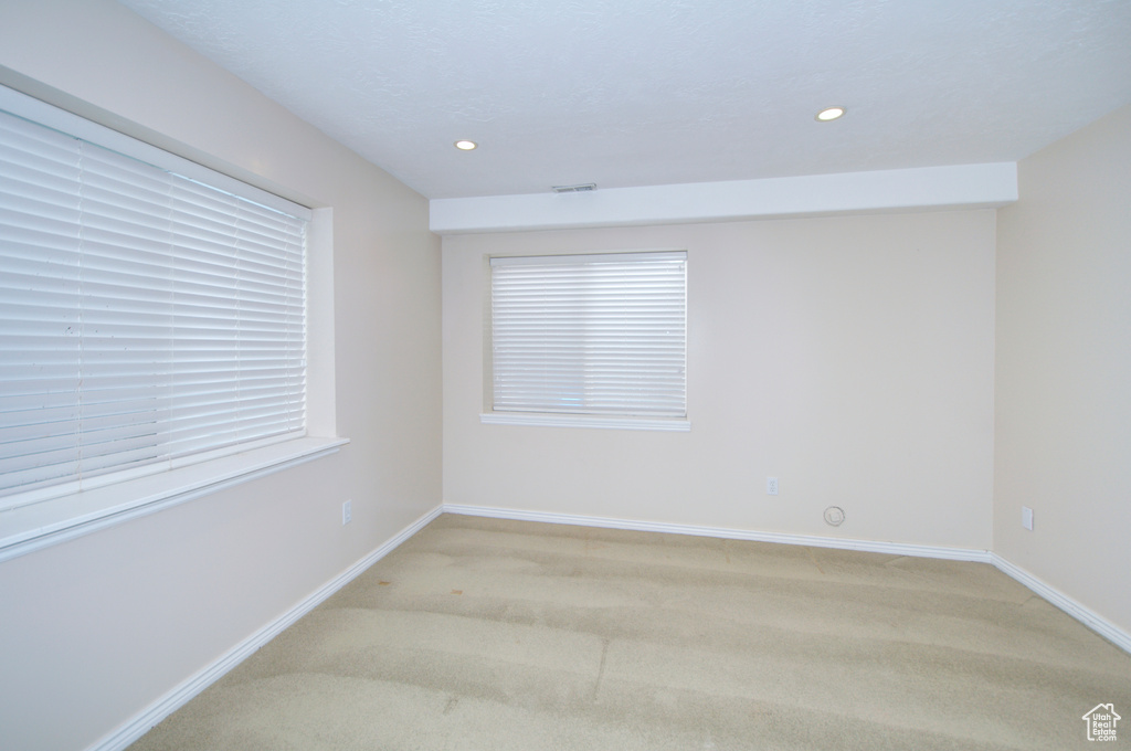 Unfurnished room featuring light carpet, baseboards, and recessed lighting