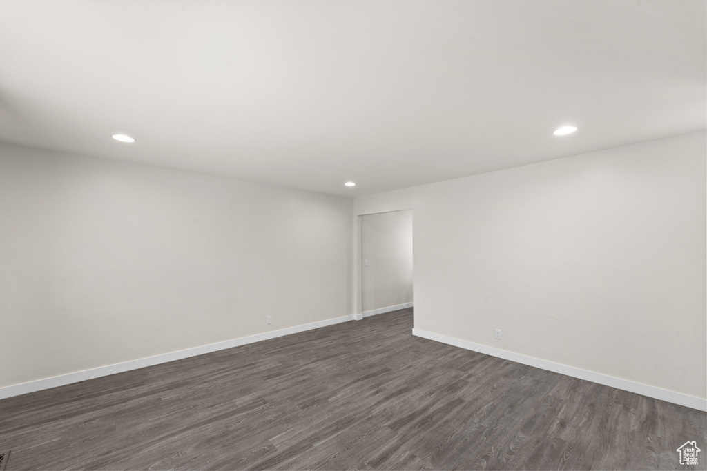 Spare room featuring recessed lighting, dark wood-style floors, and baseboards