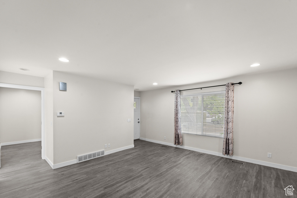 Unfurnished room with recessed lighting, dark wood-style floors, and baseboards