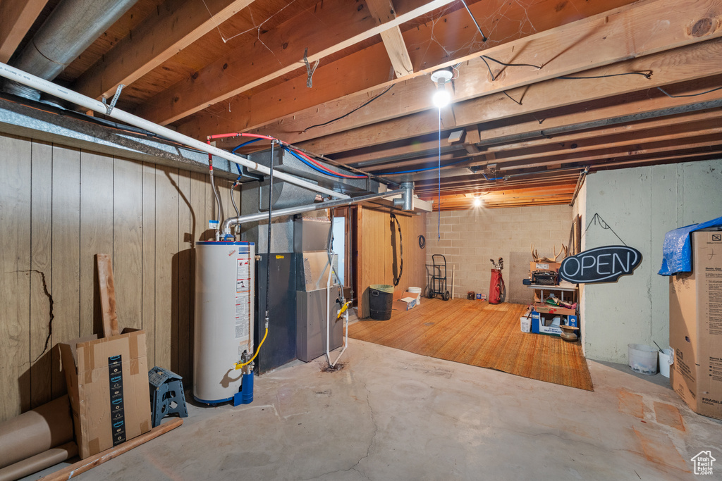 Unfinished basement featuring gas water heater and heating unit