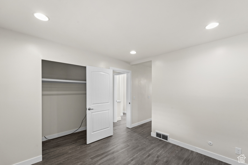 Unfurnished bedroom featuring baseboards, dark wood finished floors, recessed lighting, and a closet