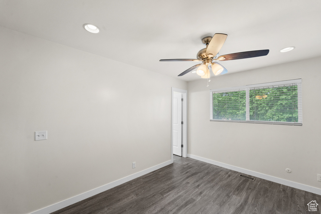 Spare room with dark wood-style flooring, ceiling fan, baseboards, and recessed lighting